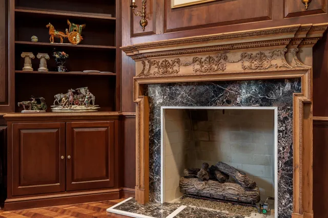 a view of a kitchen with granite countertop lots of white cabinets a stove and a chandelier