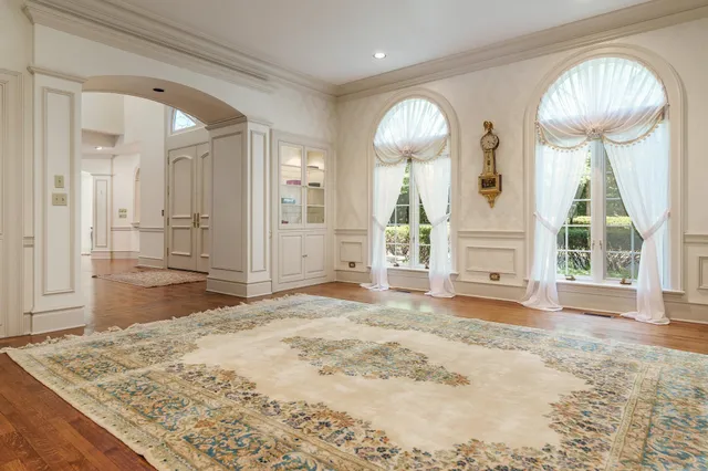 a view of a bedroom with wooden floor and windows