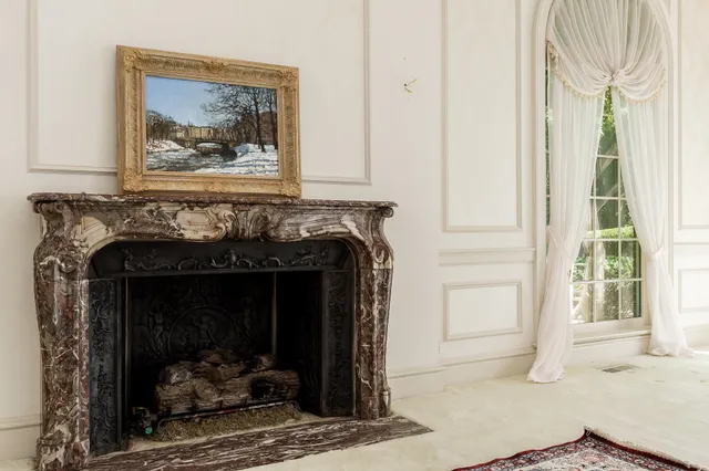 a living room with furniture a fireplace and a large window