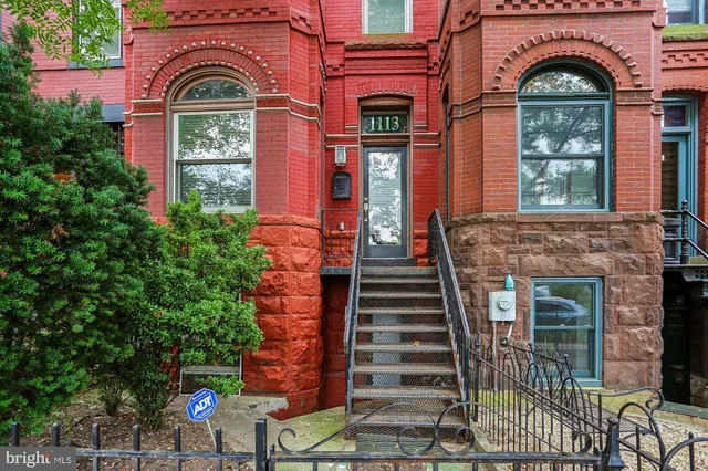 a front view of multi story residential apartment building with yard