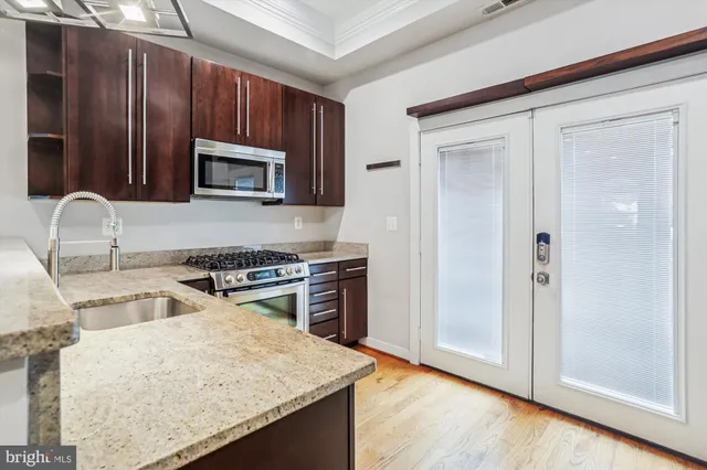 a kitchen with granite countertop wooden cabinets and stainless steel appliances