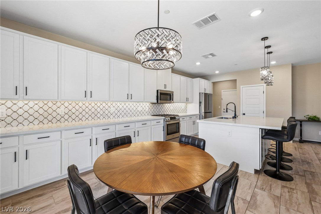 194 Viento Ridge Street Henderson, NV 89012 - Photo 11 of 72 Modern cabinetry and recessed lighting anchor this open-concept kitchen and dining area.