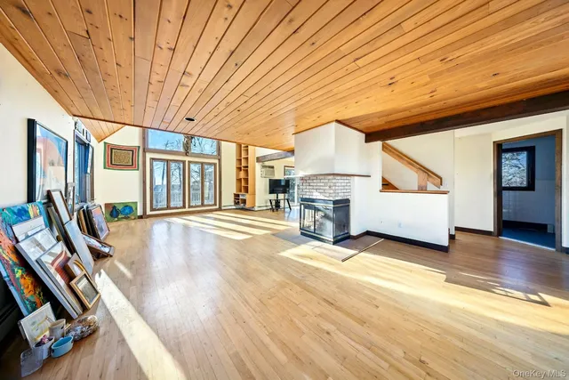 a view of an empty room with wooden floor and furniture