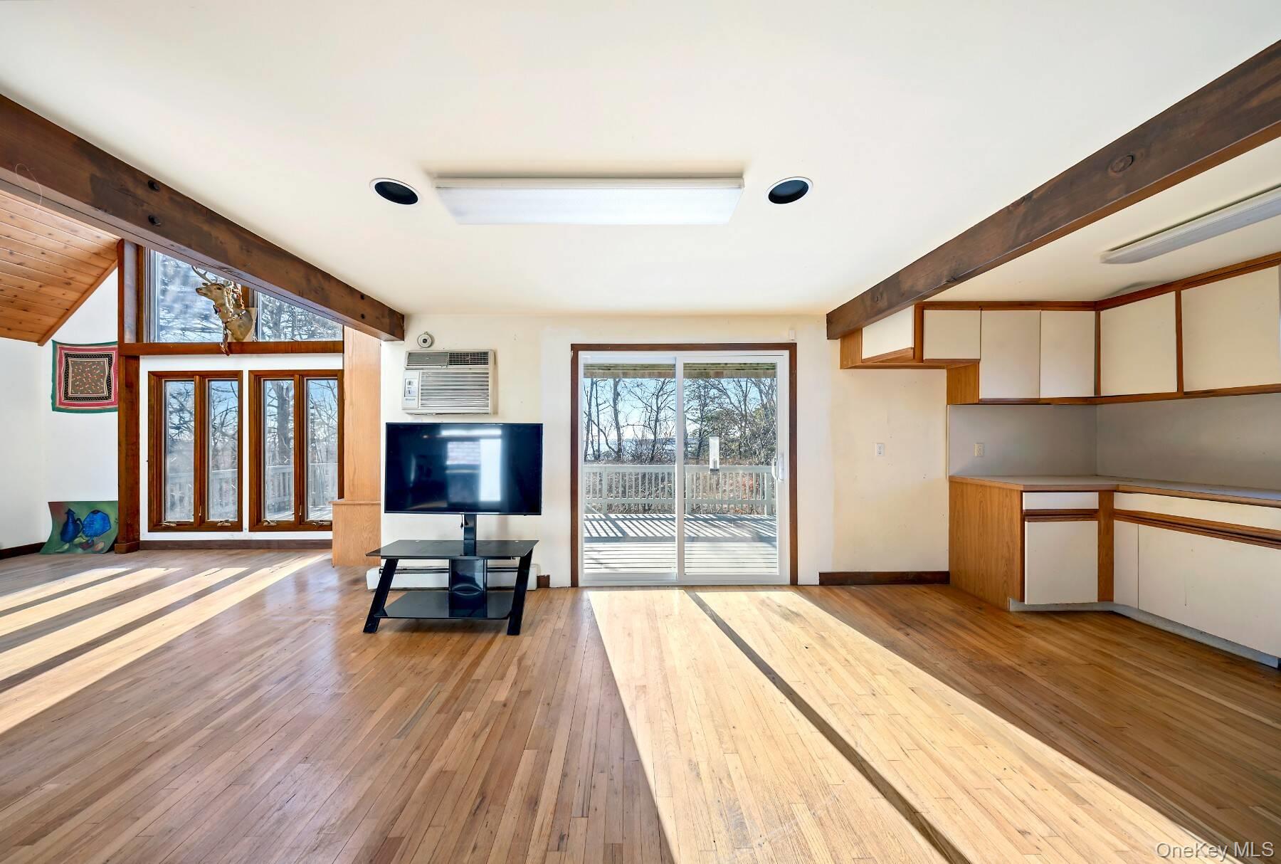 32 Old Canoe Place Road Hampton Bays, NY 11946 - Photo 7 of 12 a spacious bedroom with a bed and large windows