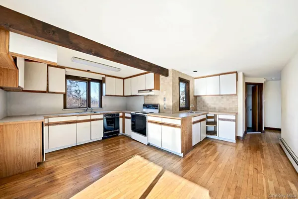 a large kitchen with a lot of counter space and wooden floor