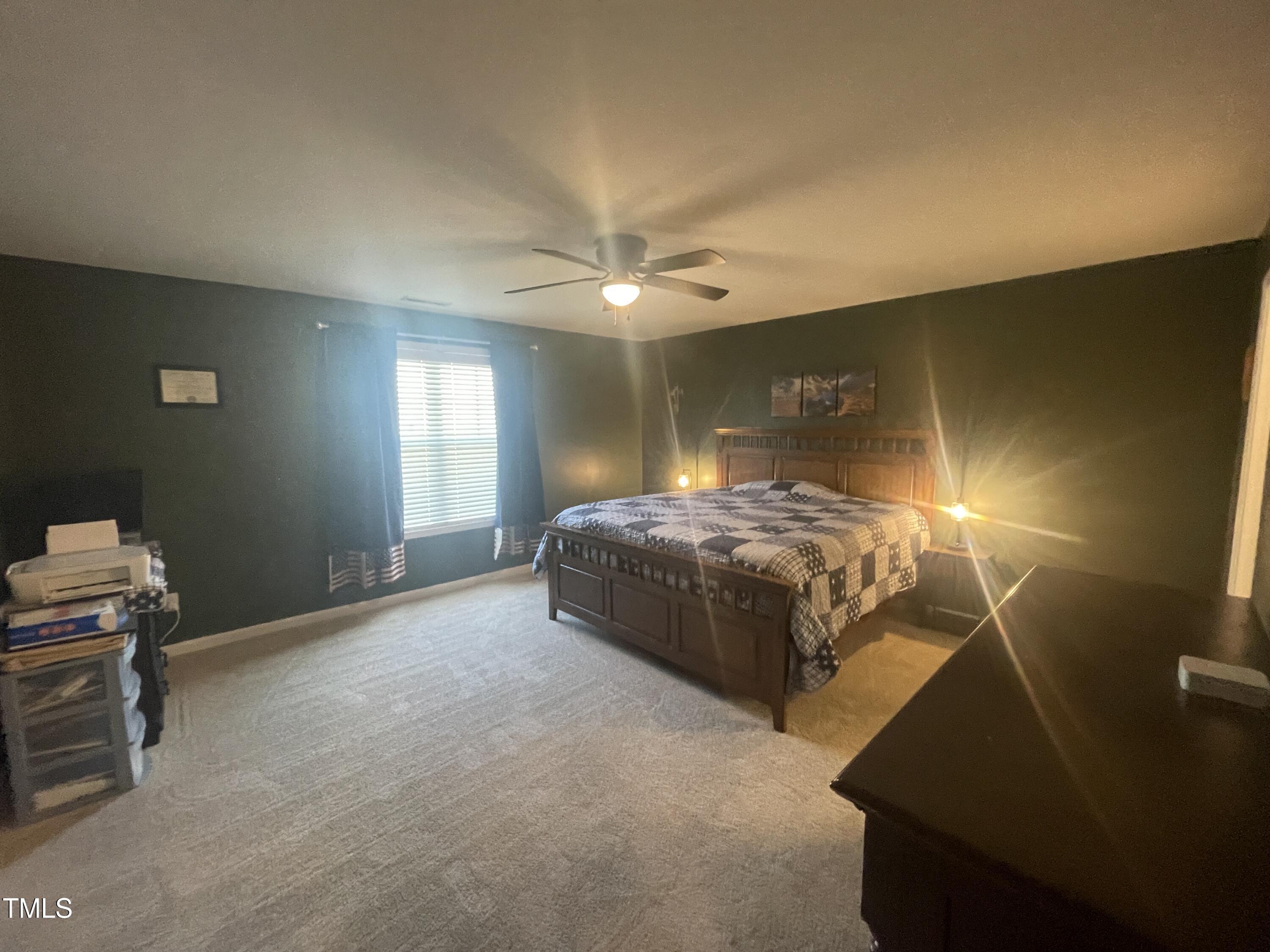 195 Presley Street Raeford, NC 28376 - Photo 18 of 37 a spacious bedroom with a bed and a chandelier