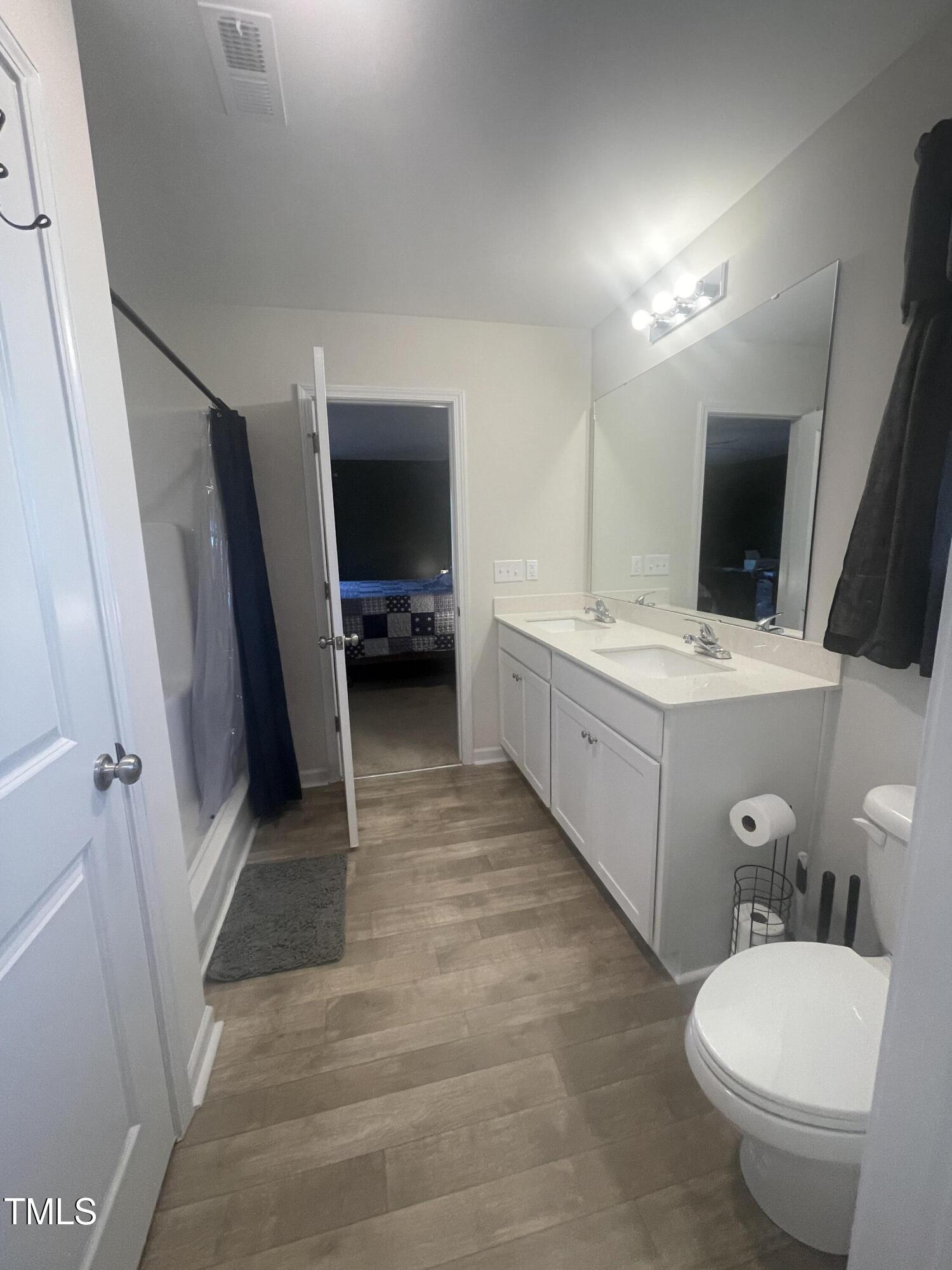 195 Presley Street Raeford, NC 28376 - Photo 25 of 37 a bathroom with a sink a toilet a mirror and vanity