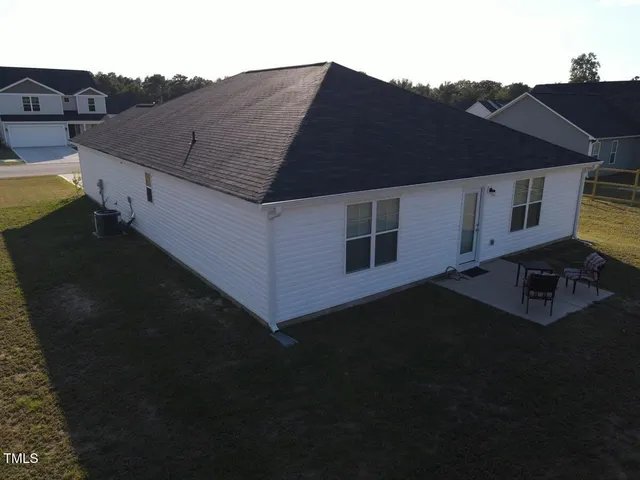 a kitchen with stainless steel appliances granite countertop a stove top oven a refrigerator a sink and white cabinets with wooden floor