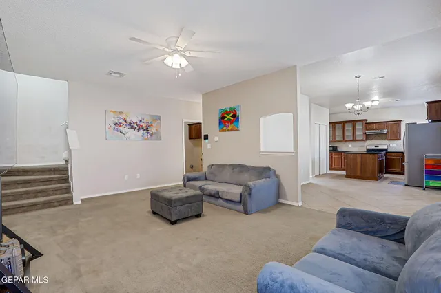 a view of a livingroom with a chandelier furniture and windows