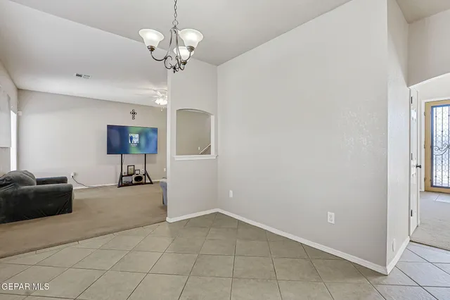 a bed sitting in a bedroom next to a window and a chandelier