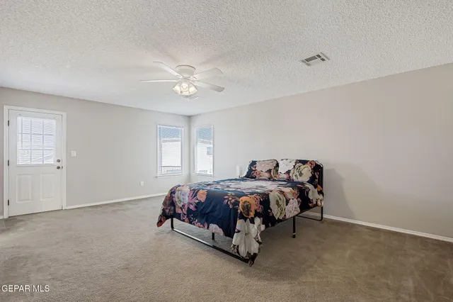 a bedroom with a bed and a chandelier fan