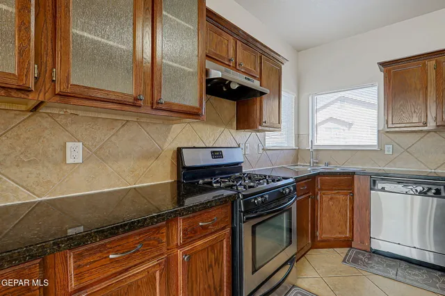 a kitchen with stainless steel appliances granite countertop a stove and a microwave