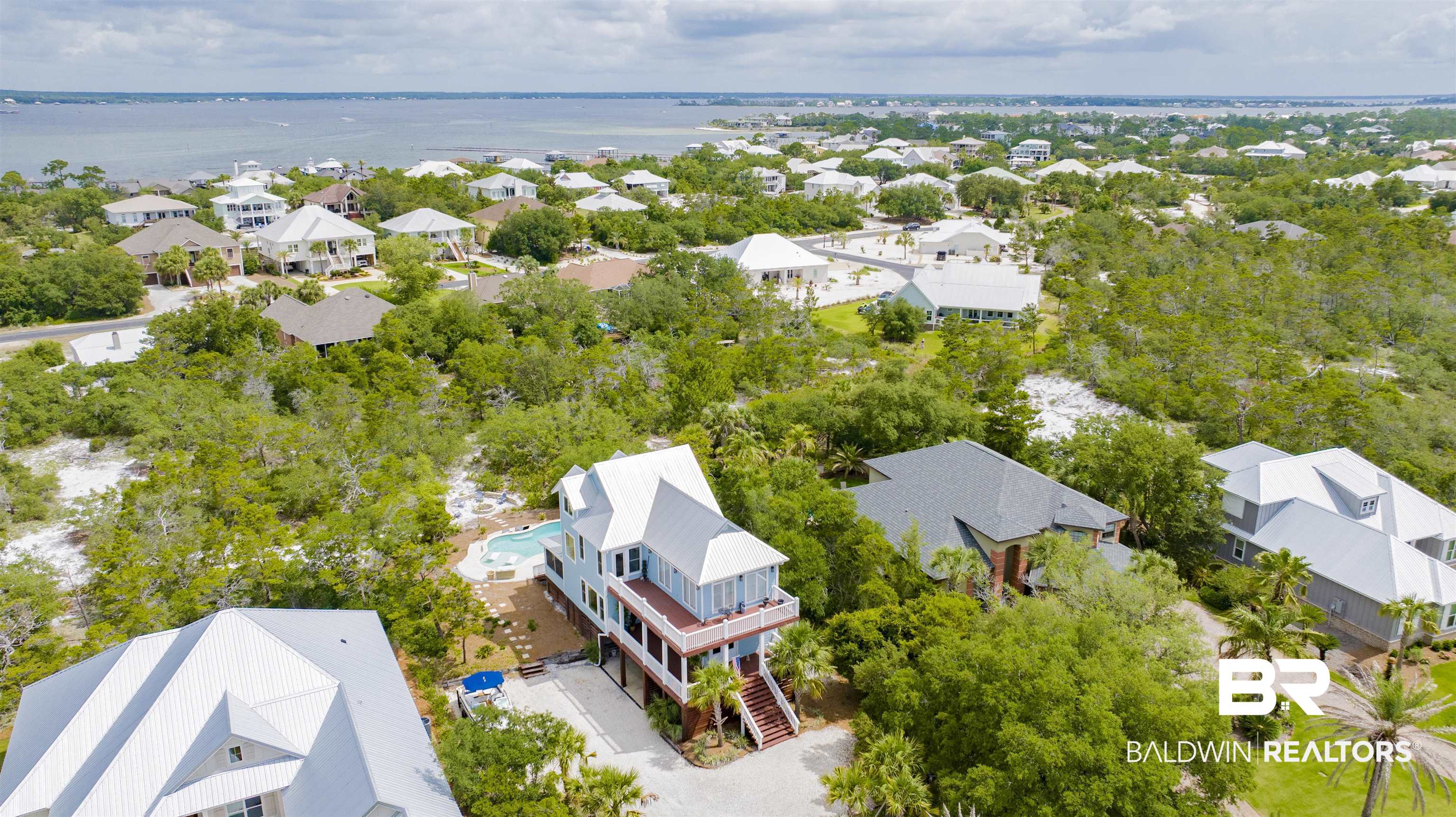 30351 River Road Orange Beach, AL 36561 - Photo 35 of 44 Elevated coastal residence featuring multiple balconies, a private swimming pool, and a white metal roof