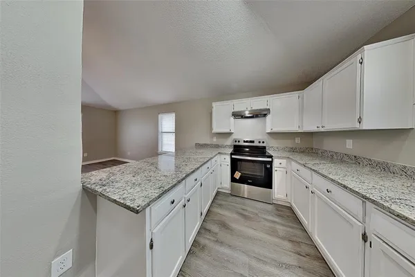 a kitchen with granite countertop wooden cabinets granite counter tops and a stove