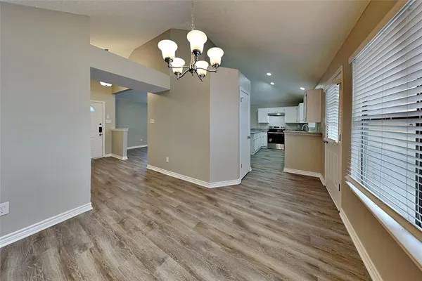 a view of a kitchen with a refrigerator a ceiling fan and wooden floor