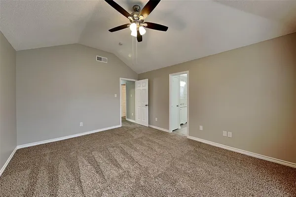 an empty room with chandelier fan