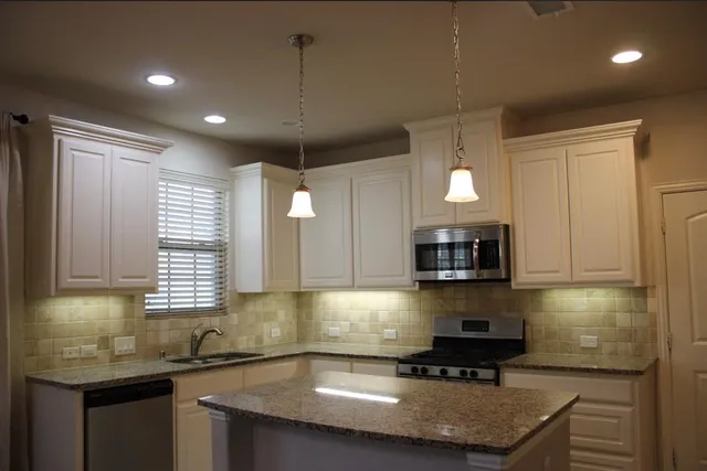 a kitchen with stainless steel appliances granite countertop a sink stove and cabinets