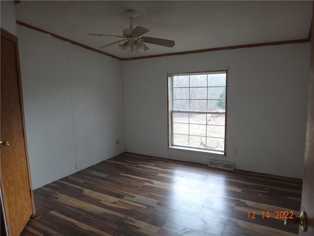 471 Millburn Road Mercer, PA 16137 - Photo 11 of 24 an empty room with wooden floor and windows with curtains