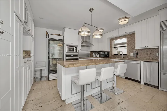 a kitchen with granite countertop cabinets stainless steel appliances and a window