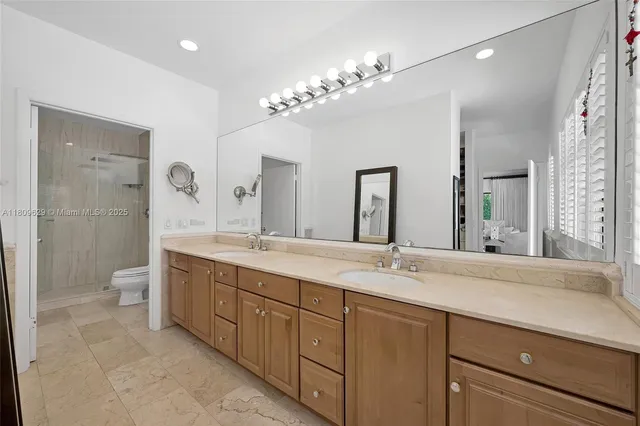 a bathroom with a granite countertop sink a toilet and shower
