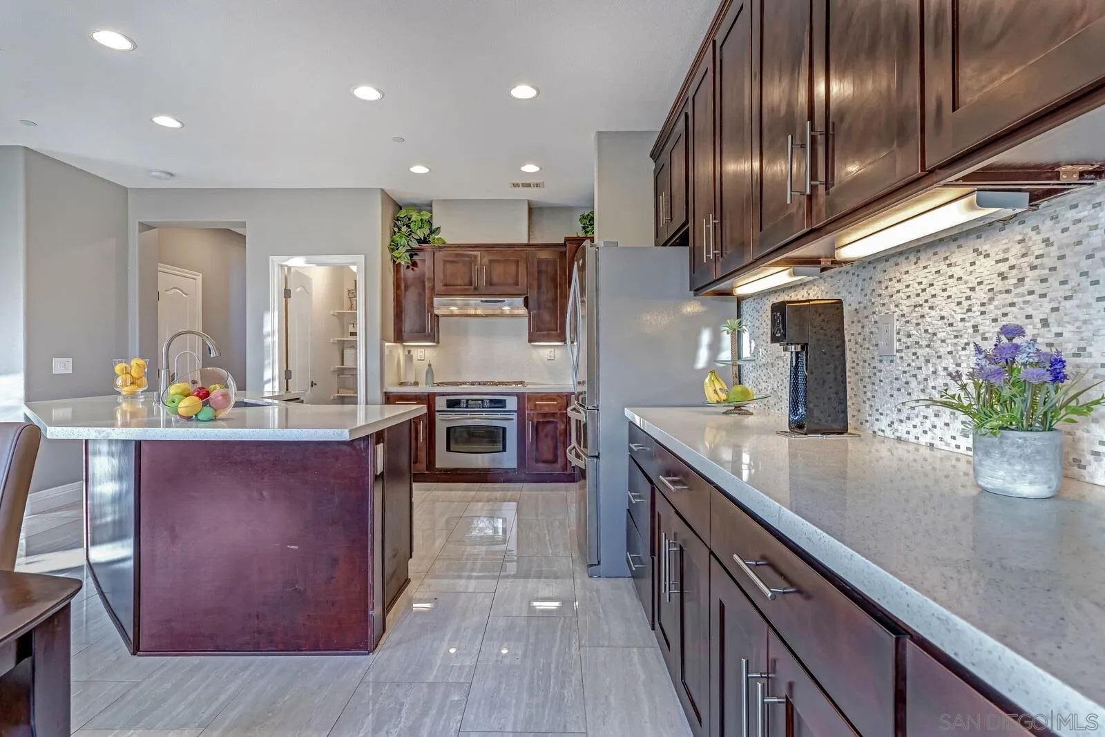 16342 Cayenne Ridge Road San Diego, CA 92127 - Photo 12 of 35 a kitchen with stainless steel appliances granite countertop counter space wooden cabinets and entryway