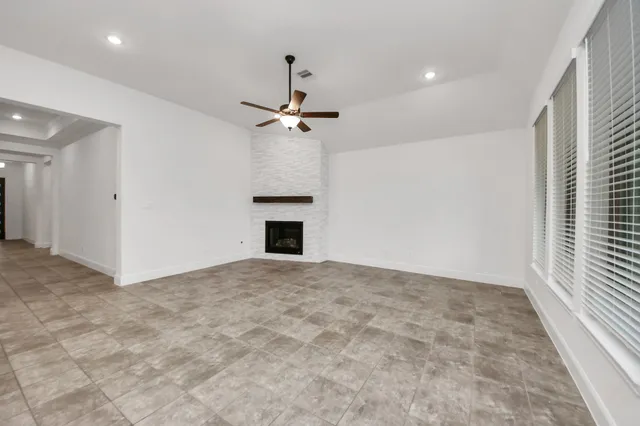 a view of empty room with a fireplace and window
