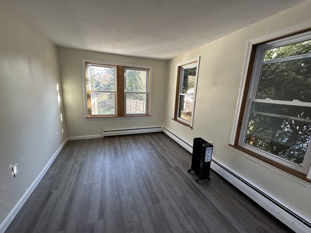 8 Pike Street Hopkinton, MA 01748 - Photo 21 of 34 a view of an empty room with wooden floor and a window