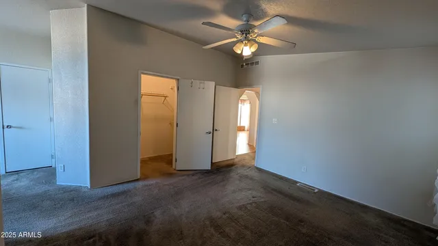 an empty room with chandelier fan