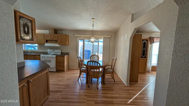 a view of a dining room with furniture a chandelier and wooden floor