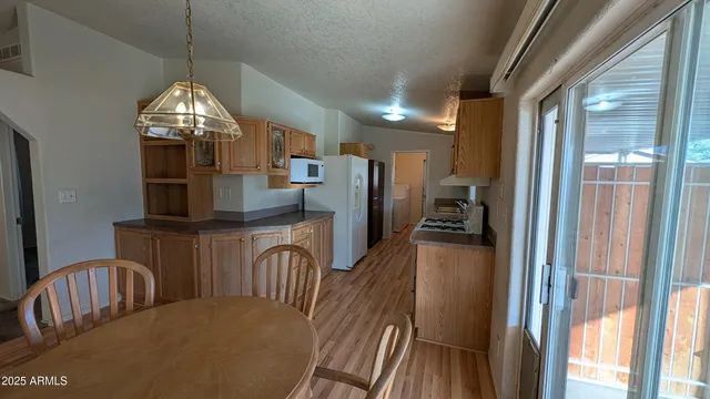 a kitchen with stainless steel appliances granite countertop a refrigerator a stove a sink dishwasher with a dining table and chairs