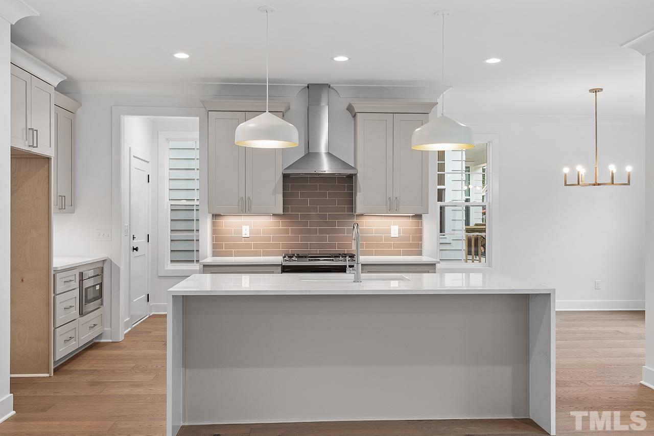 6502 Brecken Pnes Court Raleigh, NC 27612 - Photo 11 of 32 a large kitchen with stainless steel appliances a large counter top a stove and a refrigerator
