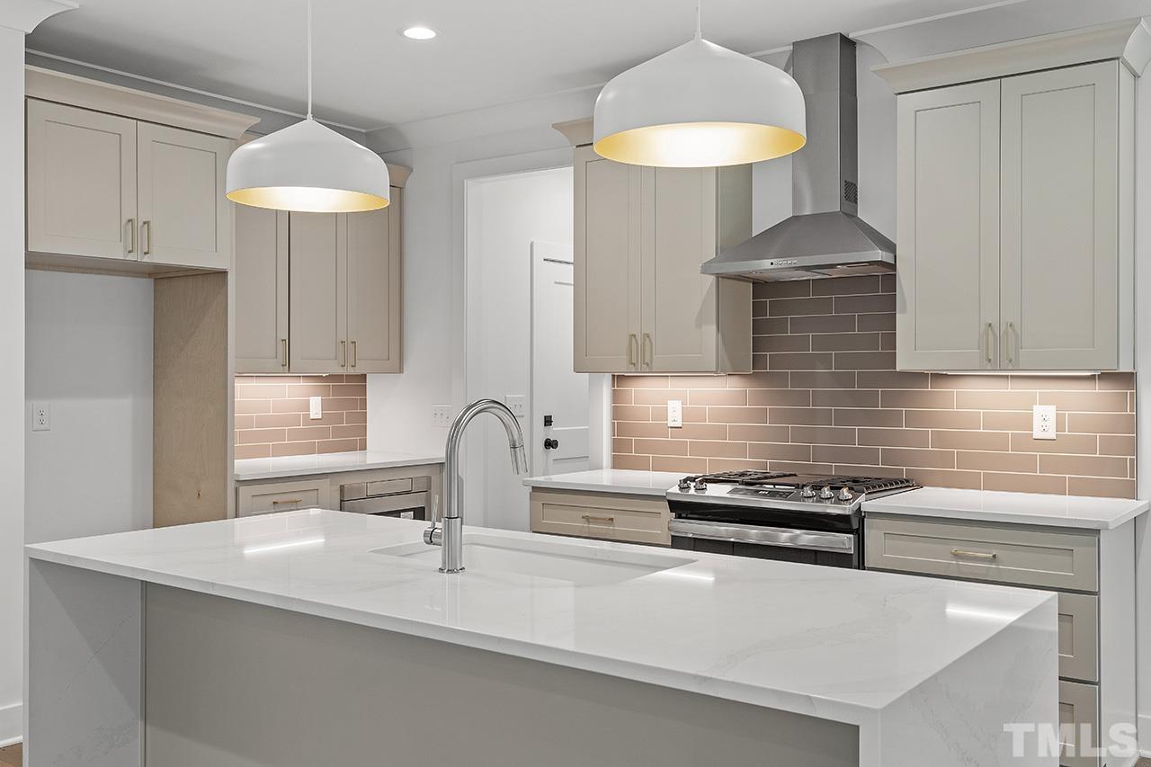 6502 Brecken Pnes Court Raleigh, NC 27612 - Photo 12 of 32 a kitchen with stainless steel appliances a sink a stove and a refrigerator