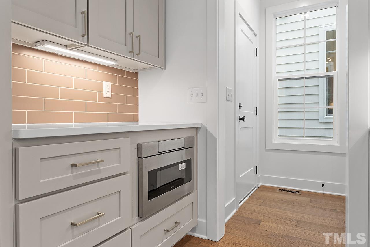 6502 Brecken Pnes Court Raleigh, NC 27612 - Photo 14 of 32 a kitchen with white cabinets and a wooden floor