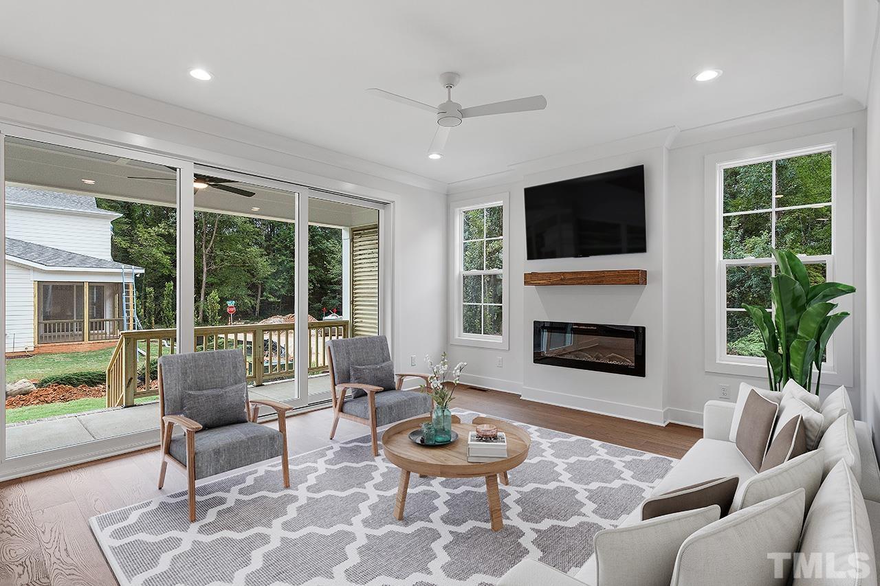 6502 Brecken Pnes Court Raleigh, NC 27612 - Photo 6 of 32 a living room with furniture a fireplace and a large window