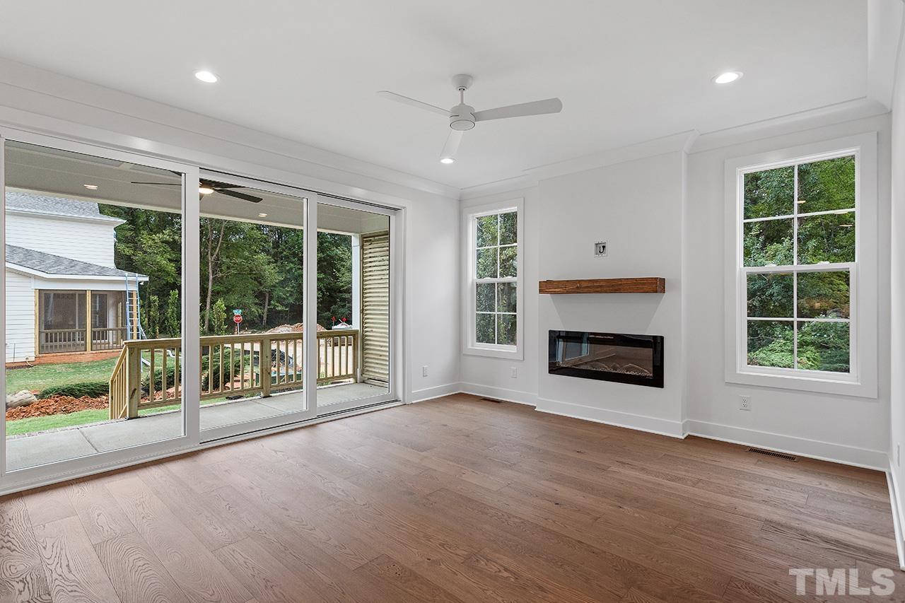 6502 Brecken Pnes Court Raleigh, NC 27612 - Photo 8 of 32 a view of an empty room with wooden floor and a fireplace