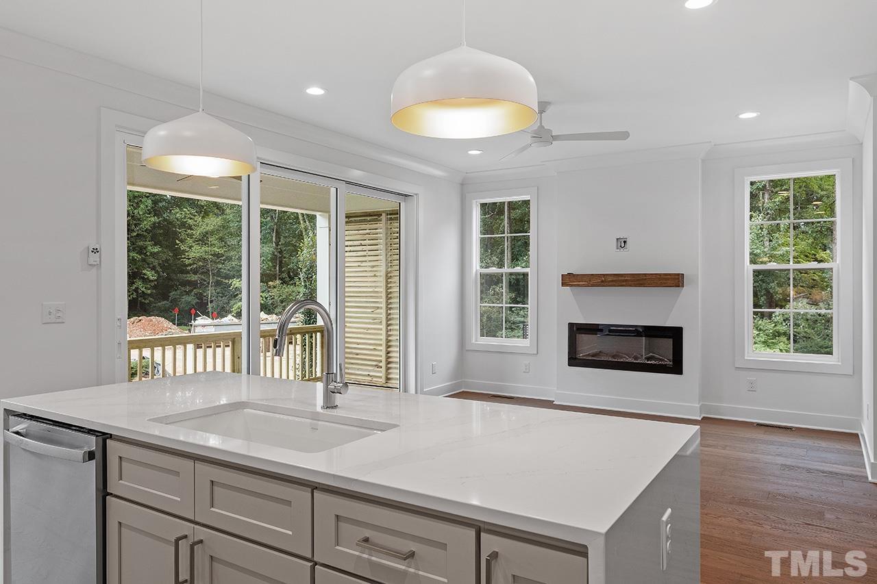 6502 Brecken Pnes Court Raleigh, NC 27612 - Photo 9 of 32 a kitchen with a sink and a fireplace