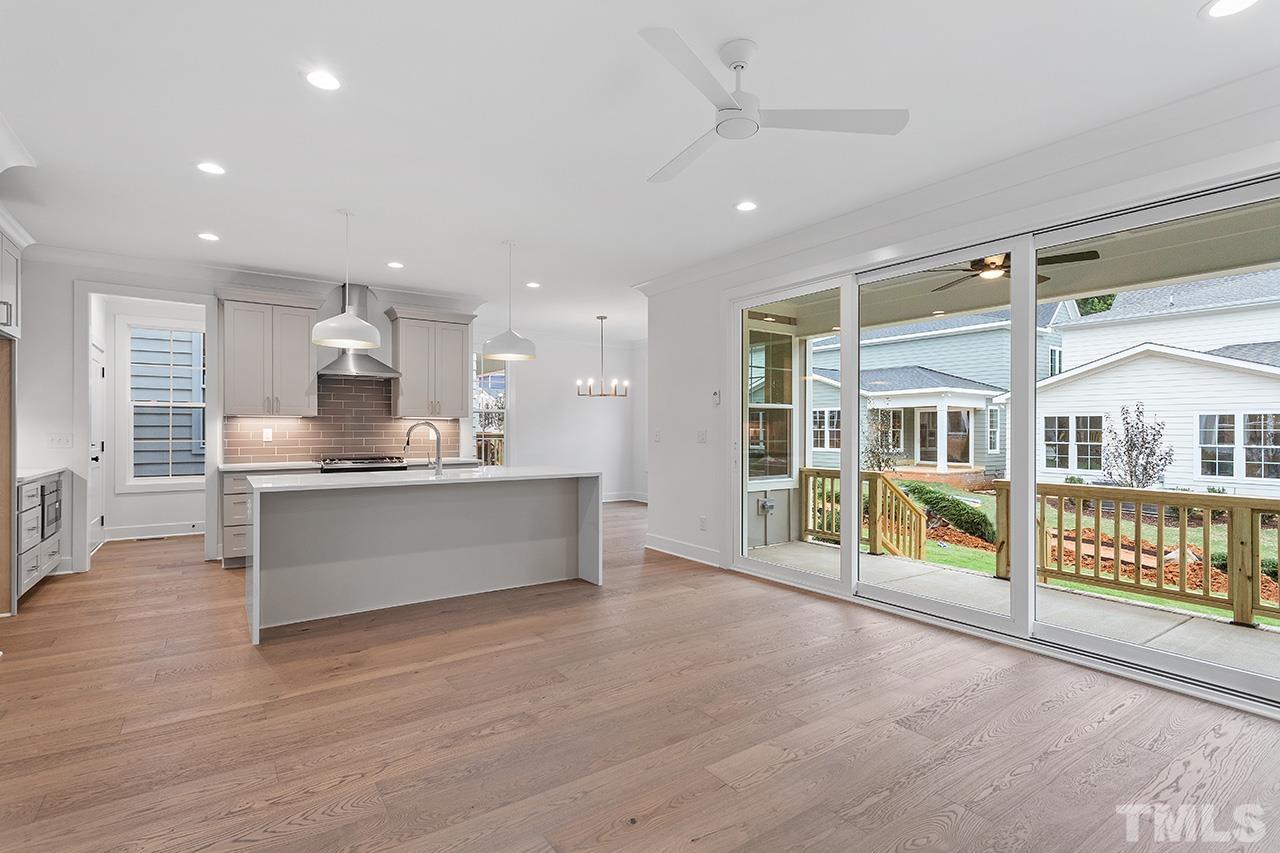 6502 Brecken Pnes Court Raleigh, NC 27612 - Photo 10 of 32 a large white kitchen with stainless steel appliances kitchen island granite countertop a large counter top and view living room