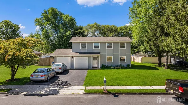 a view of a house with a patio and a yard