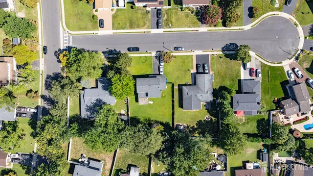an aerial view of residential houses with outdoor space and trees all around