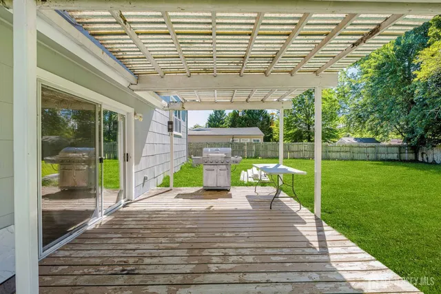 a view of a patio with a table and chairs next to a yard