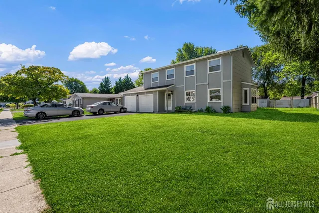 a view of a house with a big yard and large trees