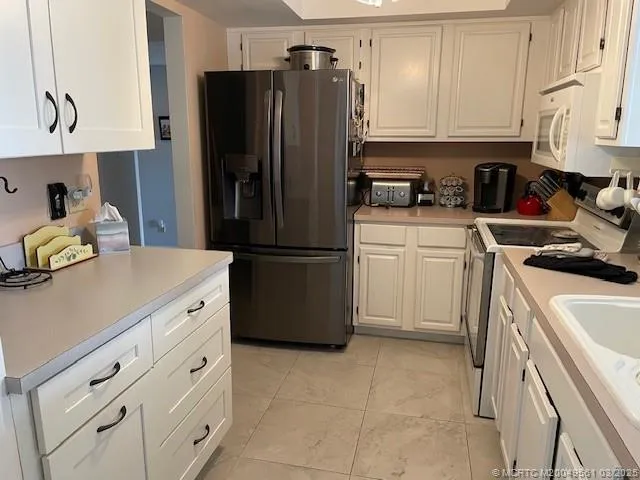 a kitchen with cabinets stainless steel appliances and a counter space
