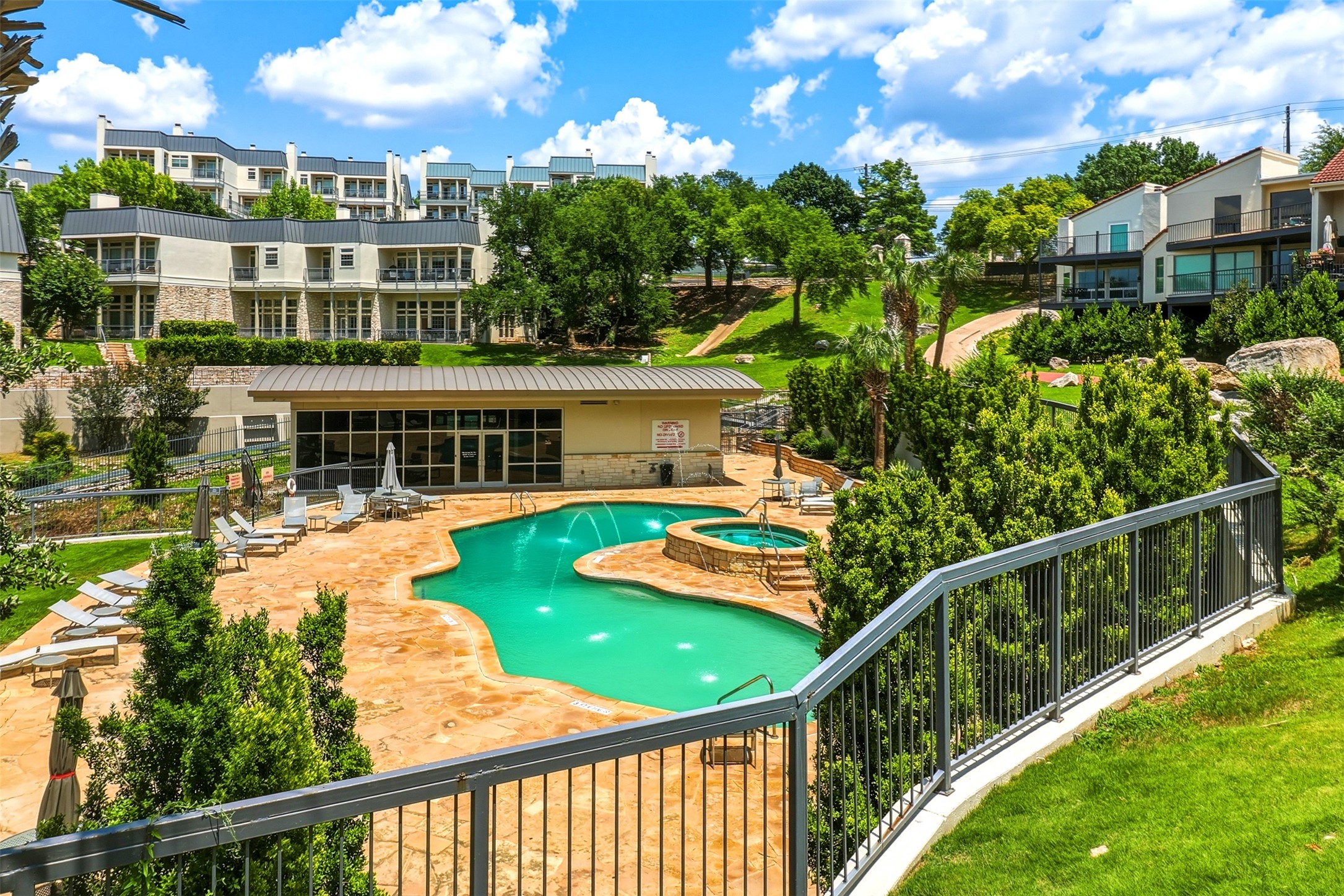 2918 Ranch Road 620, Unit 265 Austin, TX 78734 - Photo 30 of 40 An inviting pool and spa beckon amidst a lush, terraced community landscape.