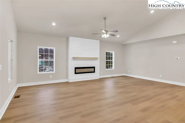 a view of an empty room with a fireplace and a window