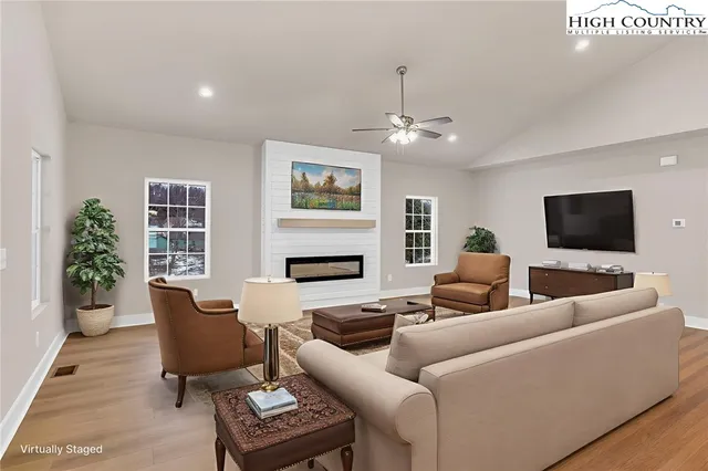a living room with furniture a fireplace and a flat screen tv