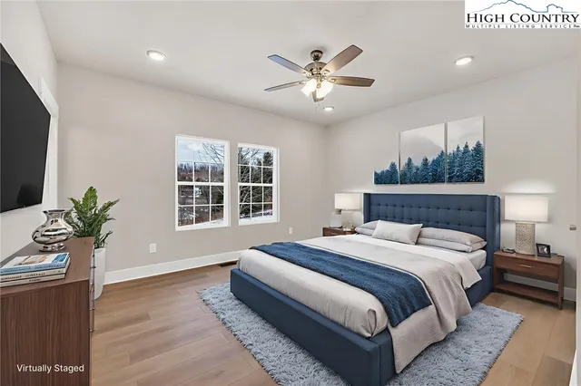 a spacious bedroom with a large bed and a potted plant