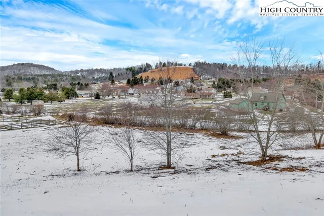 a view of a dry yard with wooden fence