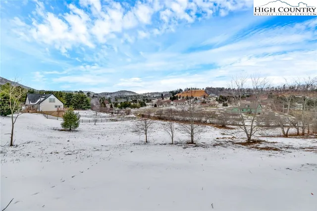a view of a dry yard with wooden fence