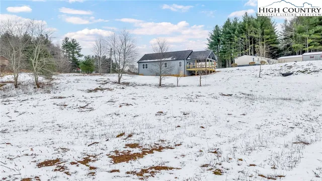 a view of a dry yard with wooden fence