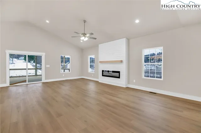 a view of an empty room with a window and fireplace